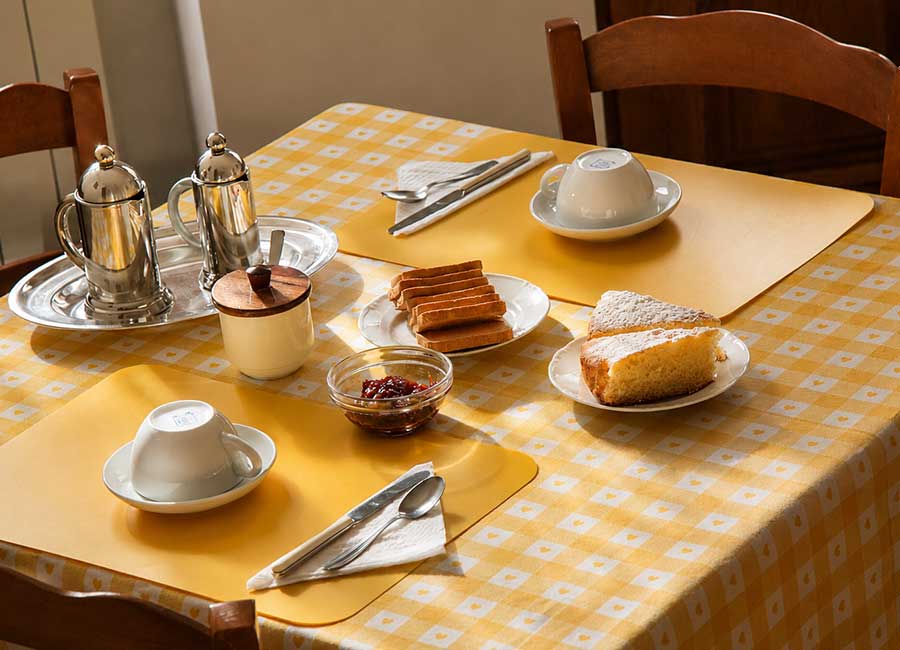 Colazione genuina del B&B Opi La Sosta con caffè, dolci fatti in casa, marmellata e fette biscottate in un ambiente familiare.