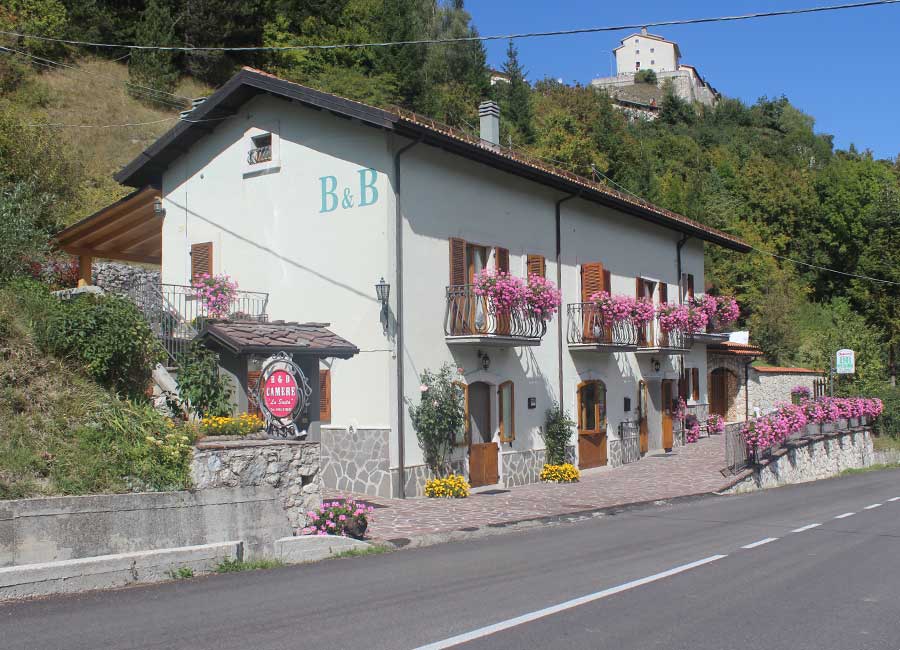 B&B familiare Opi La Sosta visto dall’esterno, con la struttura lungo la strada e il borgo di Opi sullo sfondo.