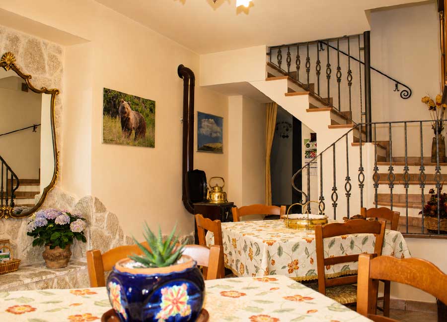 B&B familiare Opi La Sosta, sala comune accogliente con tavoli, arredi in legno e atmosfera autentica di casa.