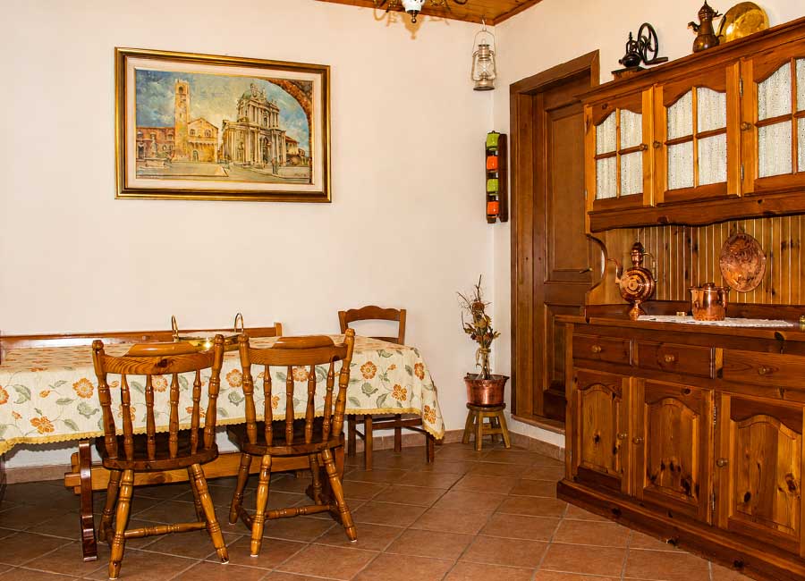 B&B familiare Opi La Sosta, sala interna con credenza in legno, tavoli apparecchiati e dettagli tradizionali.
