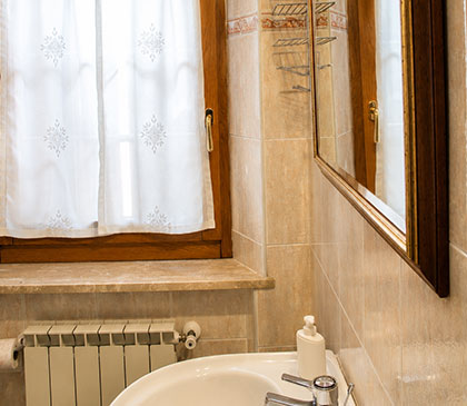Camere Opi al B&B La Sosta, bagno privato con lavabo, specchio e ambiente pulito e luminoso.