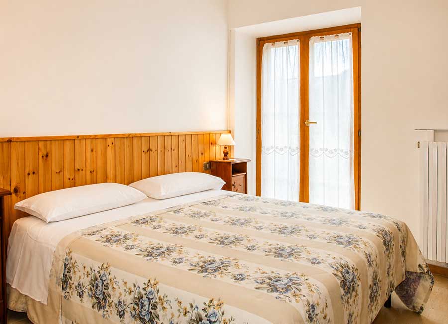 Camere Opi al B&B La Sosta, camera matrimoniale con finestra, luce naturale e arredi semplici in legno.
