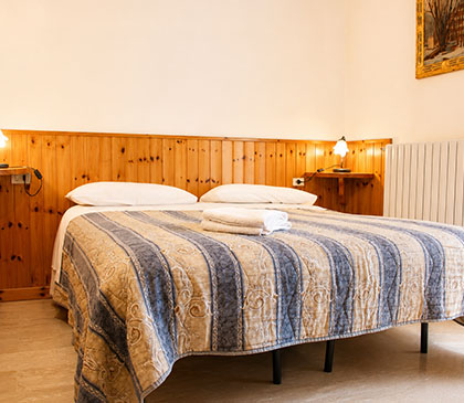 Camere Opi al B&B La Sosta, letto matrimoniale preparato con asciugamani e dettagli curati per un soggiorno tranquillo.